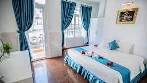 A hotel room with a bed, a white wardrobe, a potted plant, and a view of the outside balcony. - Tea Leaf Hotel (Cam Ly - Da Lat)