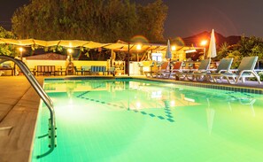 A swimming pool with lounge chairs and umbrellas, surrounded by trees and a mountain in the background. - Ada Apart Hotel (Ortaca)