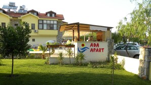 A small outdoor seating area with a sign reading "ADA APART" and a building in the background. - Ada Apart Hotel (Ortaca)