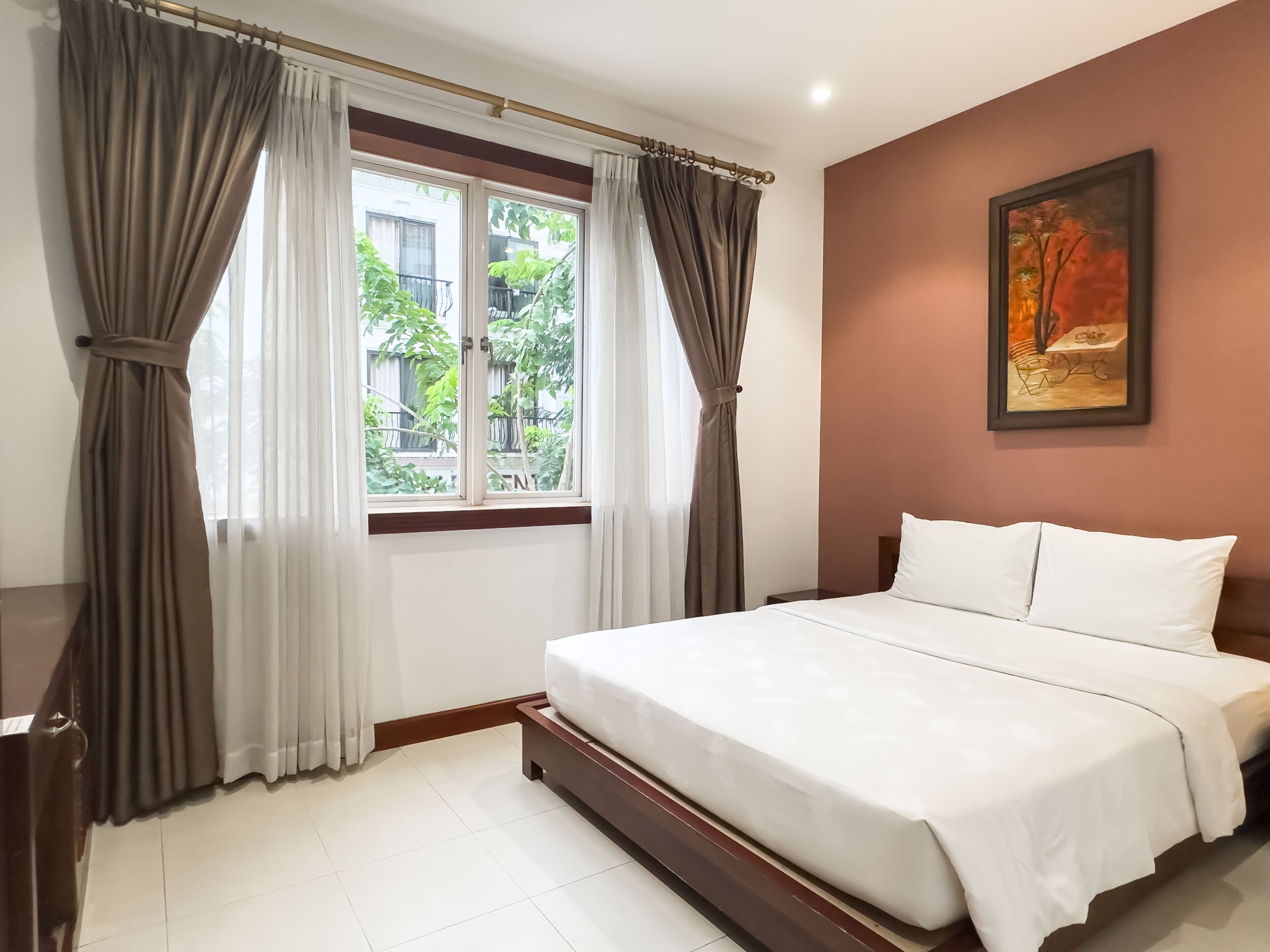 A bedroom with a bed, curtains, a window, and a painting on the wall.