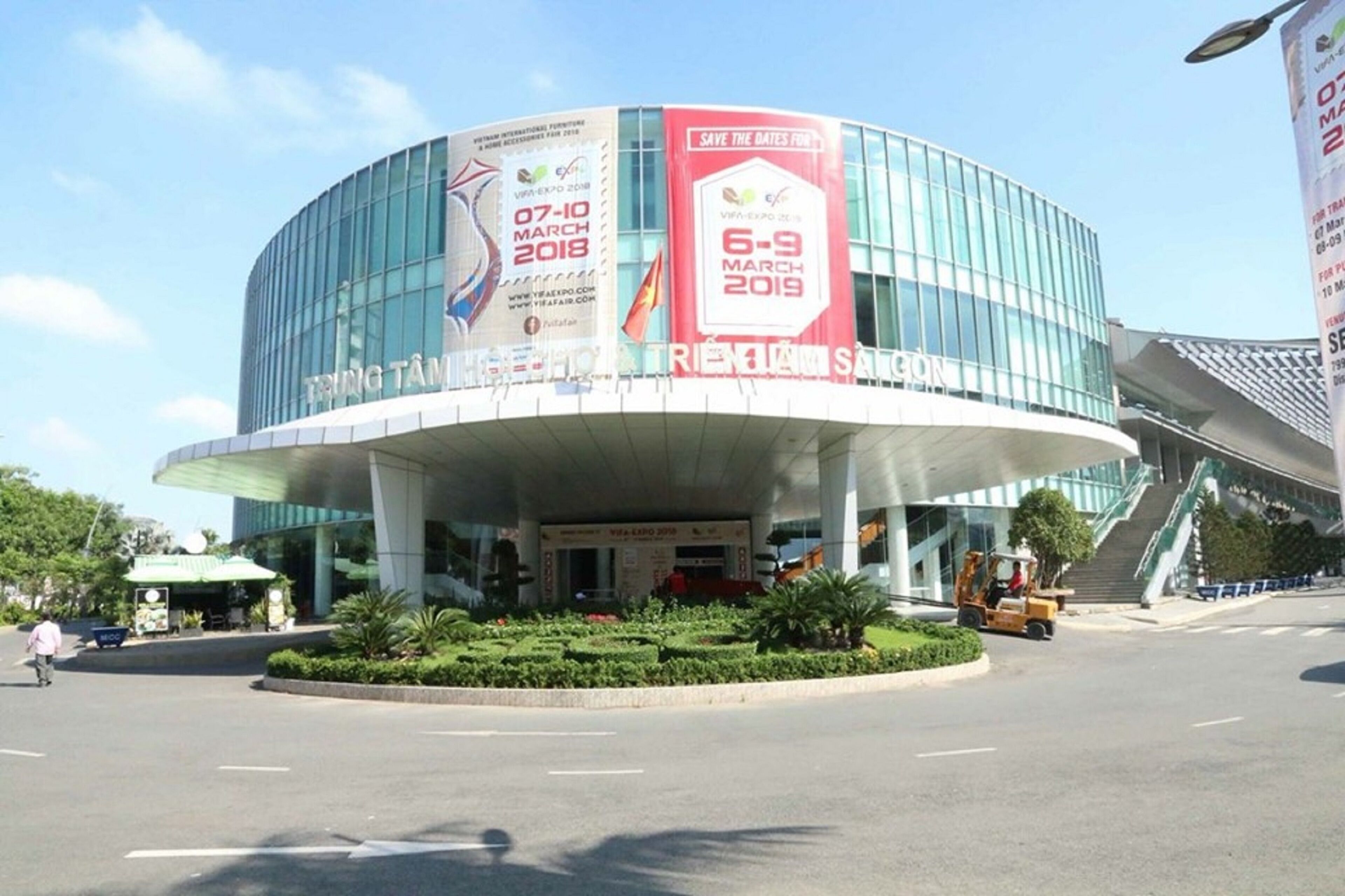 A modern building with a curved glass facade and a covered entrance area.