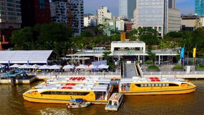 Un grand ferry jaune, doté de plusieurs ponts, était amarré à un terminal situé au bord de l’eau.