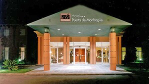 A hotel entrance with a large canopy, columns, and a sign reading "Hotel Puerta de Monfrague." - Hotel ELE Puerta de Monfragüe (Malpartida de Plasencia)