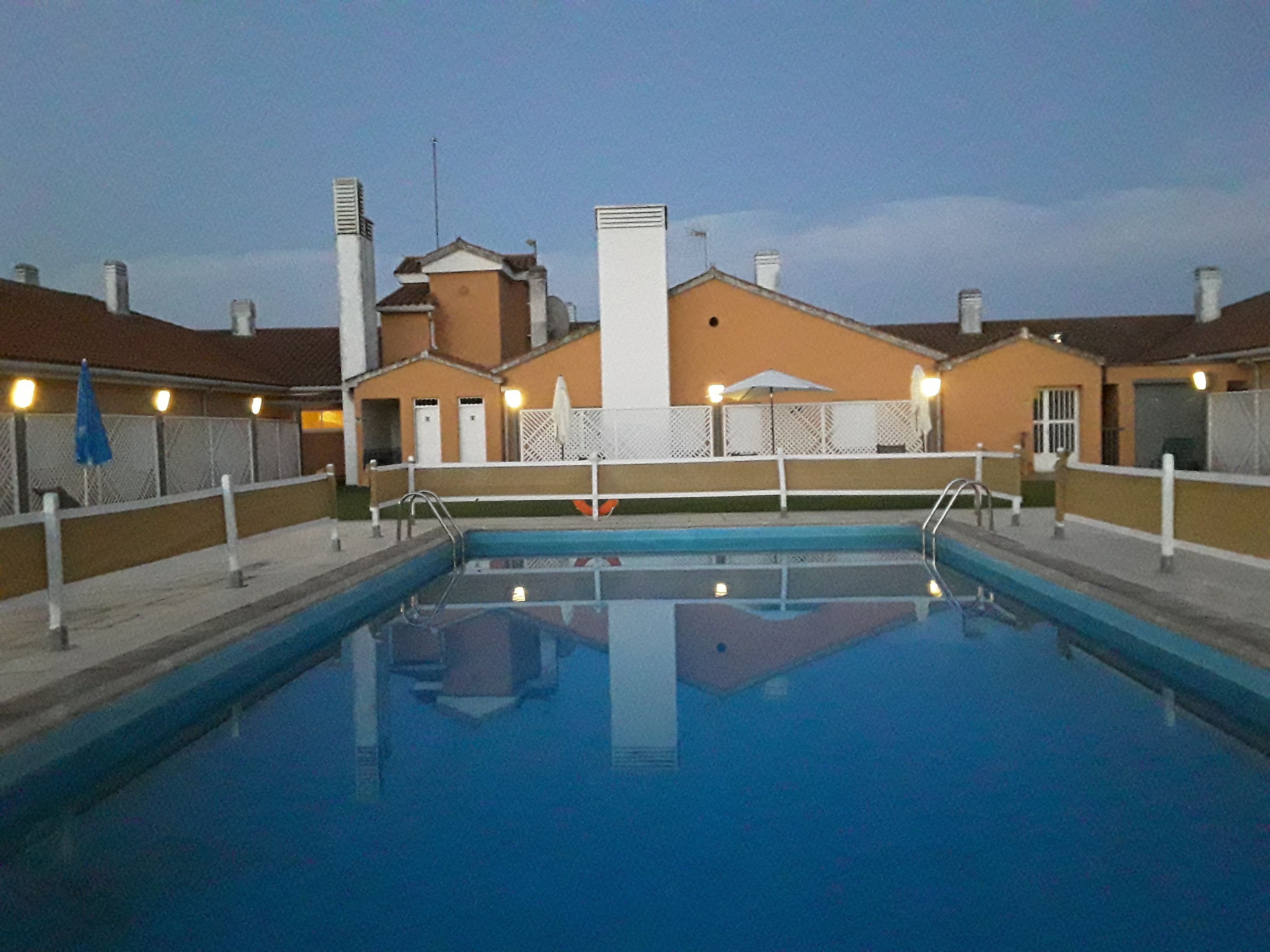 Una piscina con vistas despejadas de los edificios circundantes y una valla.