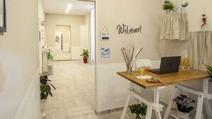 A hotel reception area with a wooden desk, a laptop, and a 'Welcome!' sign. - B&B Pontenuovo Bed (Naples)