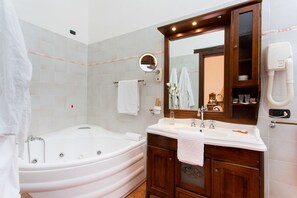 A bathroom with a freestanding bathtub, a vanity with a mirror, and a towel rack.