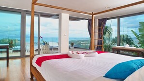 Un dormitorio con una cama grande, un balcón con vistas y estructura de techo de madera.
