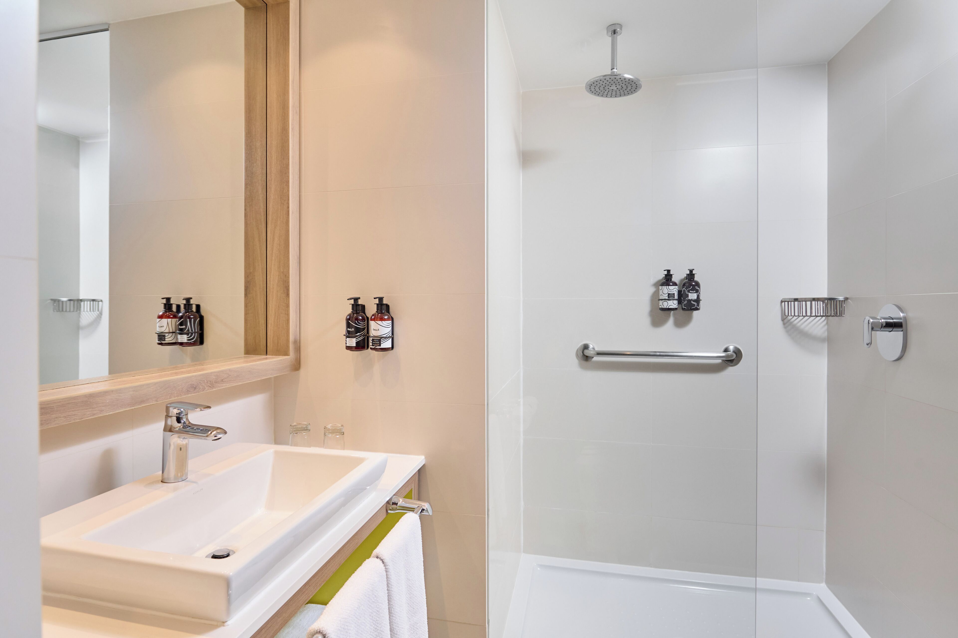 A modern bathroom with a sink, mirror, and shower.