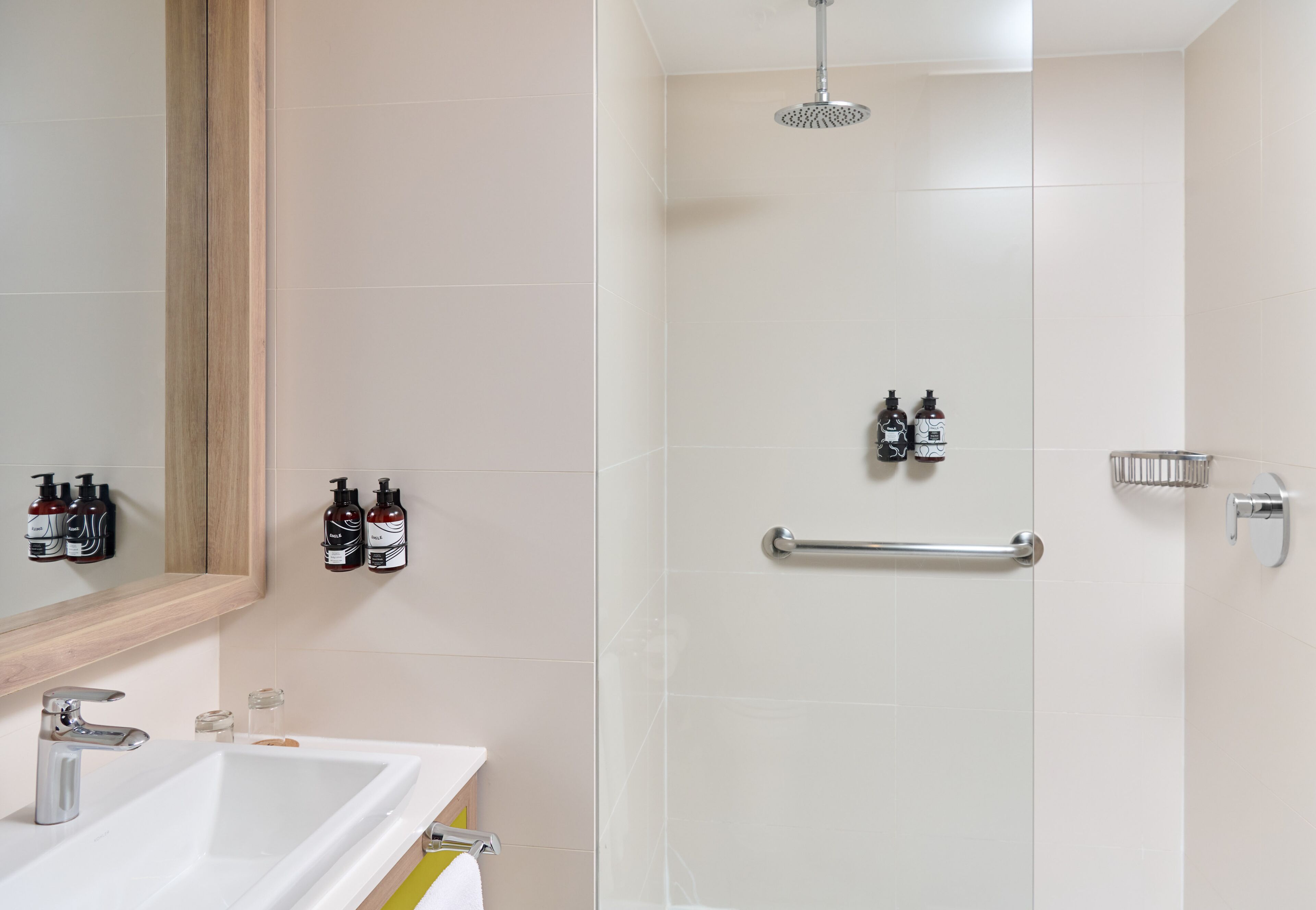 A modern bathroom with a white sink, mirror, and shower.