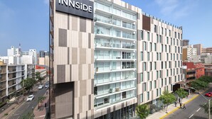 A multi-story hotel with a modern design, featuring a prominent 'INNSIDE' sign on the facade.