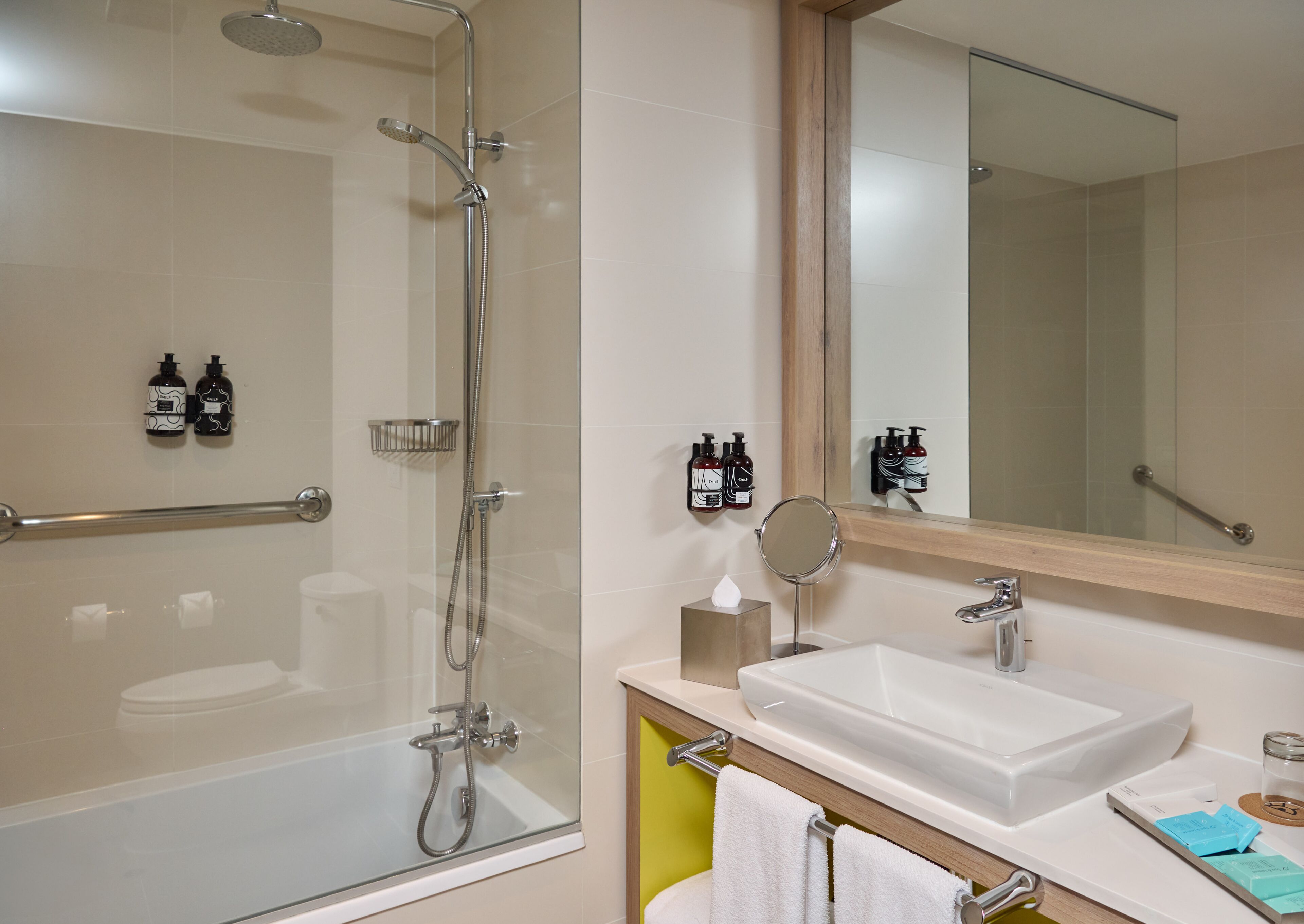 A modern bathroom with a glass-enclosed shower, a white sink, and a mirror above the sink.