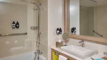 A modern bathroom with a glass-enclosed shower, a white sink, and a mirror above the sink.