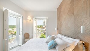 Un dormitorio con una cama grande, vista a través de una puerta abierta y una pared con diseño geométrico.