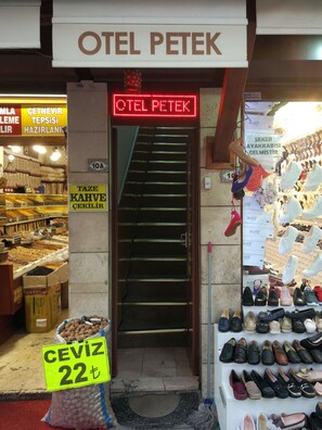 L’entrée d’un hôtel appelé « OTEL PETERK », avec un escalier menant à l’intérieur.