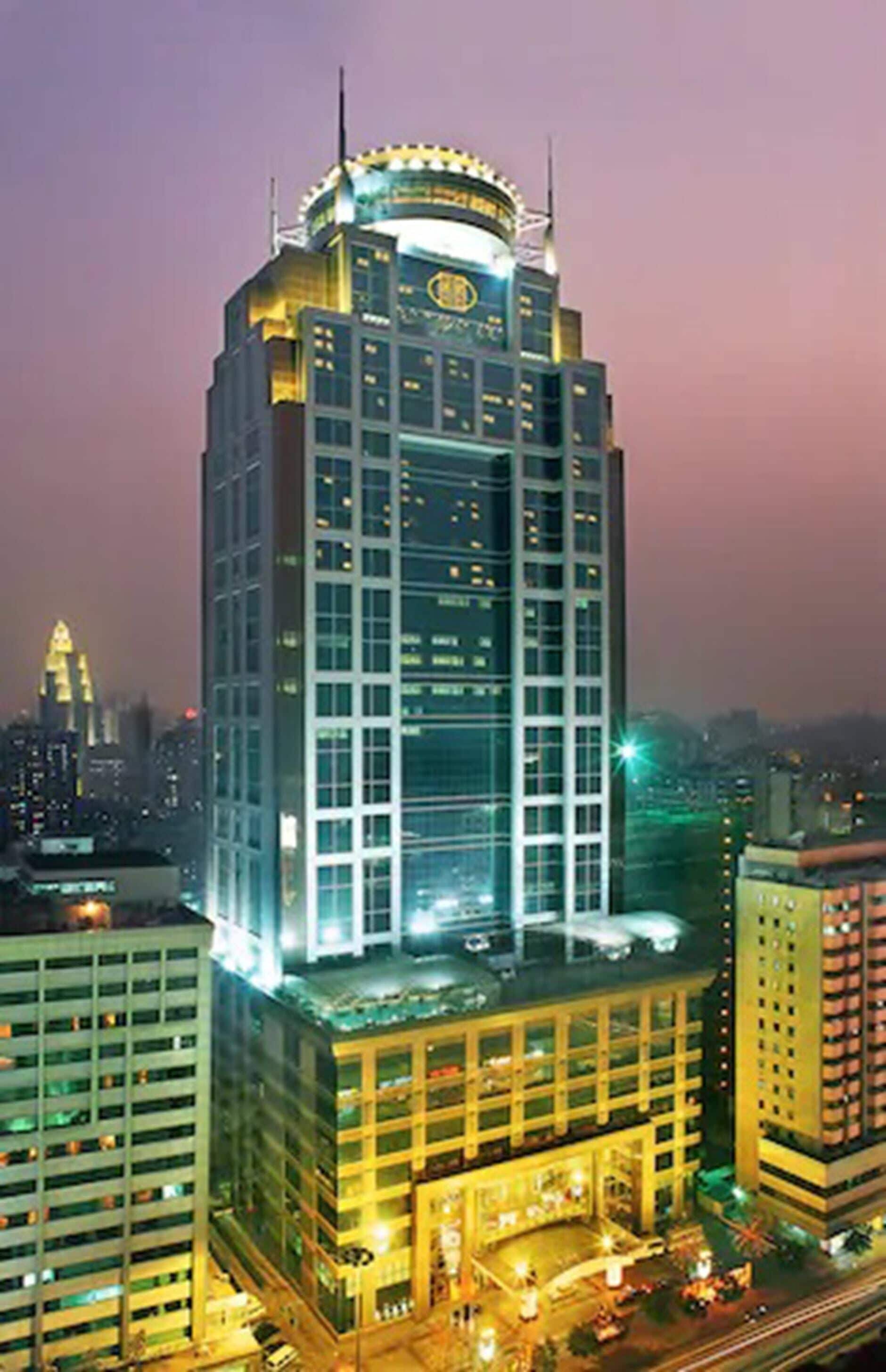 A high-rise building with a prominent glass facade and a distinctive top structure.