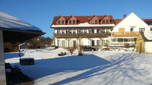 A two-story house with a snow-covered roof and a car parked in front. - Landhaus Vesper (Lichtenfels)