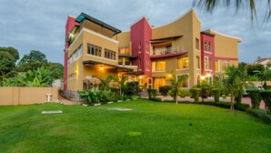 Um hotel de vários andares com design moderno, com varandas e um jardim bem cuidado.