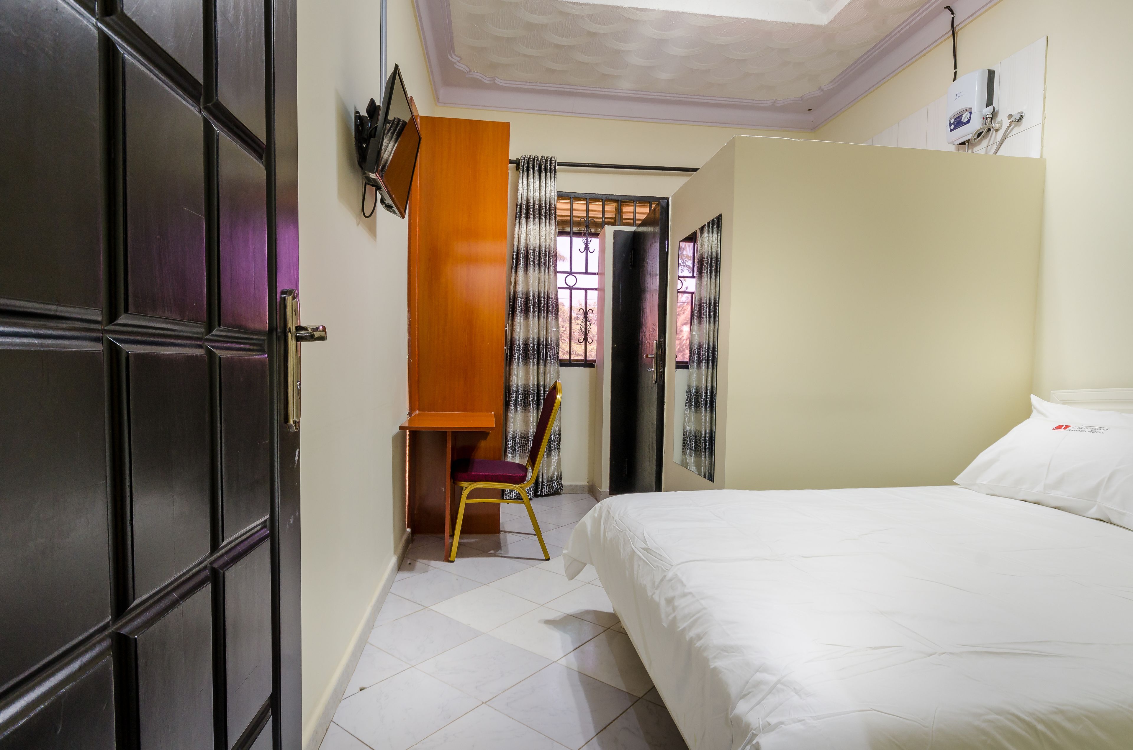 Un dormitorio con cama, escritorio y silla.