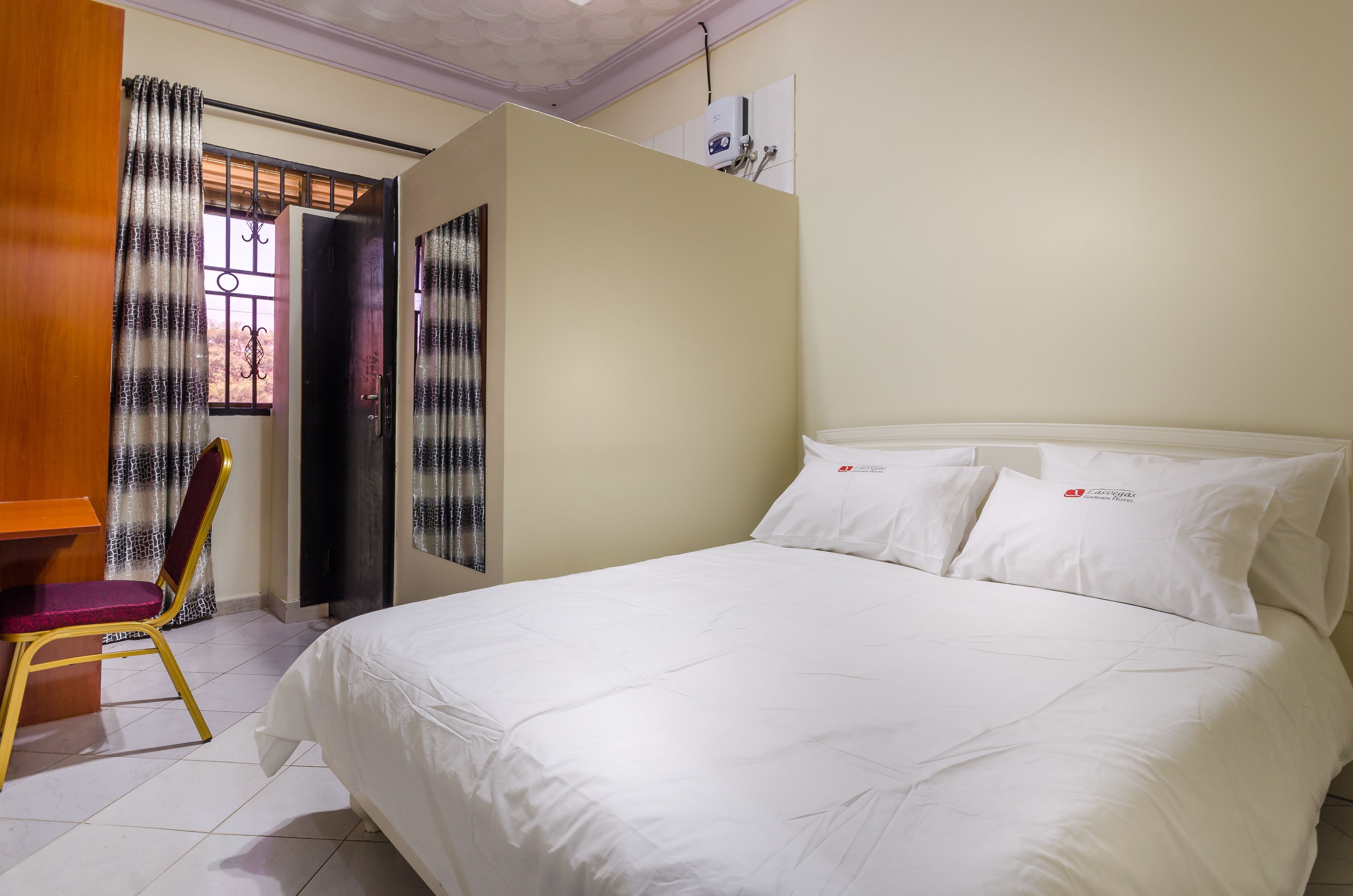 Une chambre d’hôtel avec un lit, un bureau et une chaise.