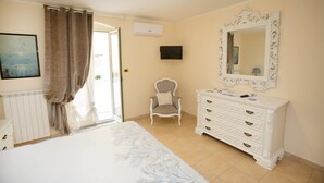 A bedroom with a bed, a dresser, a chair, a television, and a window with curtains. - Antica Dimora B&B Canosa (Canosa di Puglia)