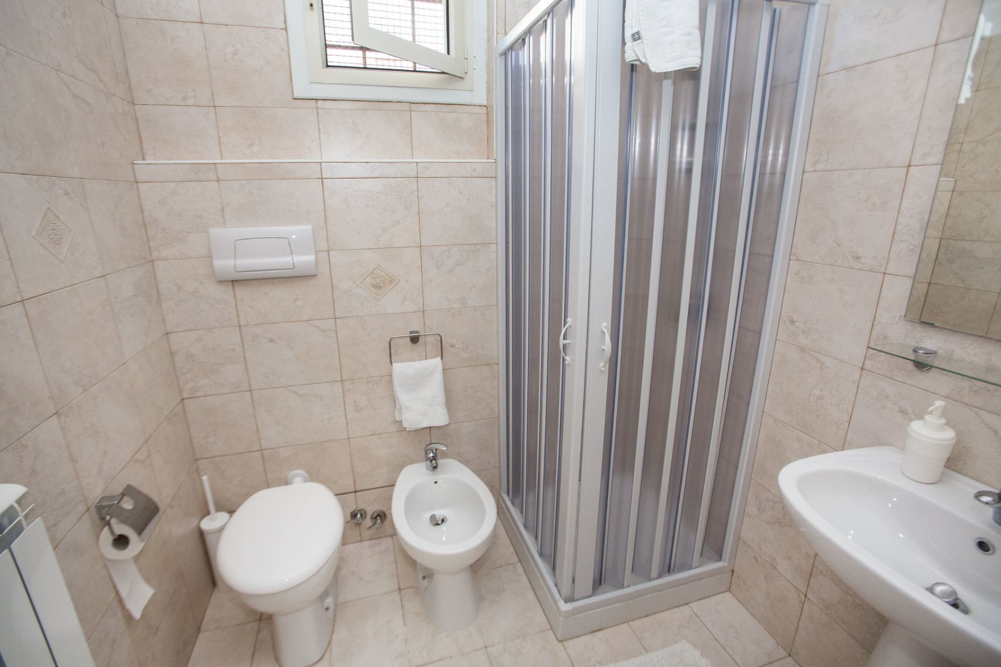 A bathroom with a toilet, bidet, and a shower enclosure.