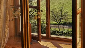 A room with a large window offering a view of a green landscape. - Rittergut Positz GmbH (Oppurg)