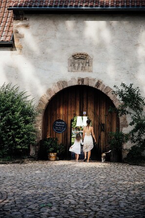 A rustic stone building with a wooden door and a sign.