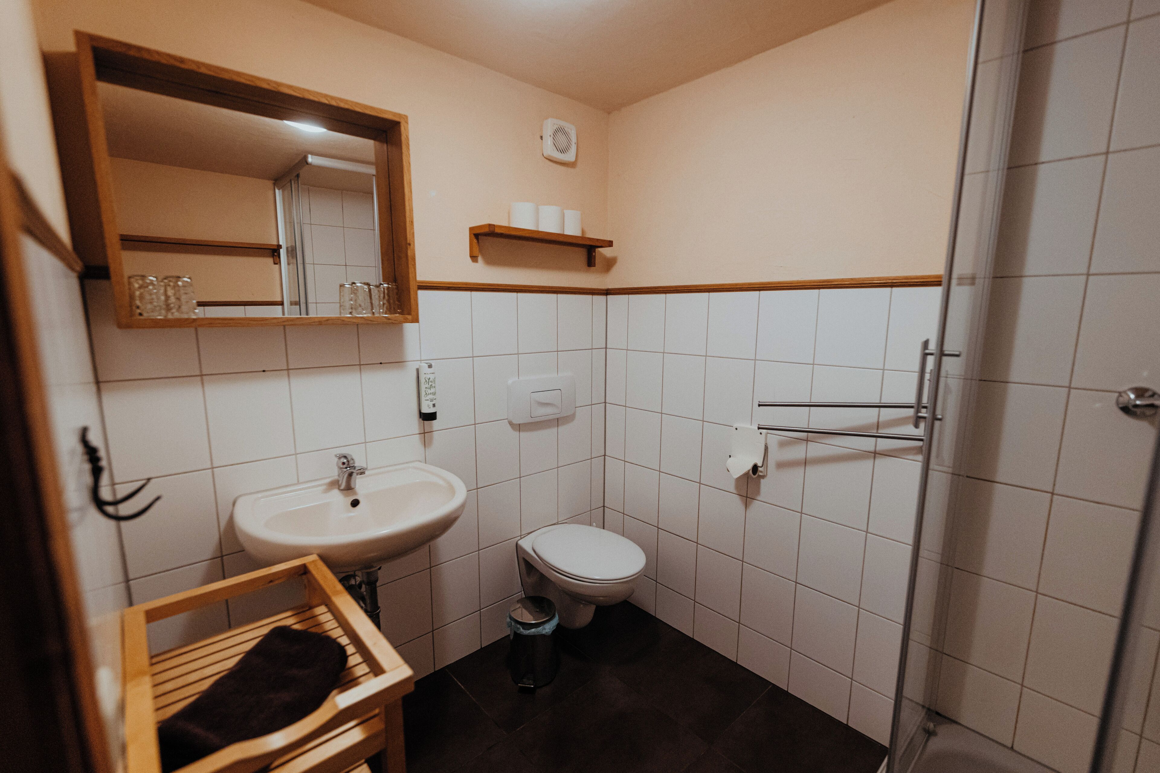 A small bathroom with a sink, toilet, and a mirror.