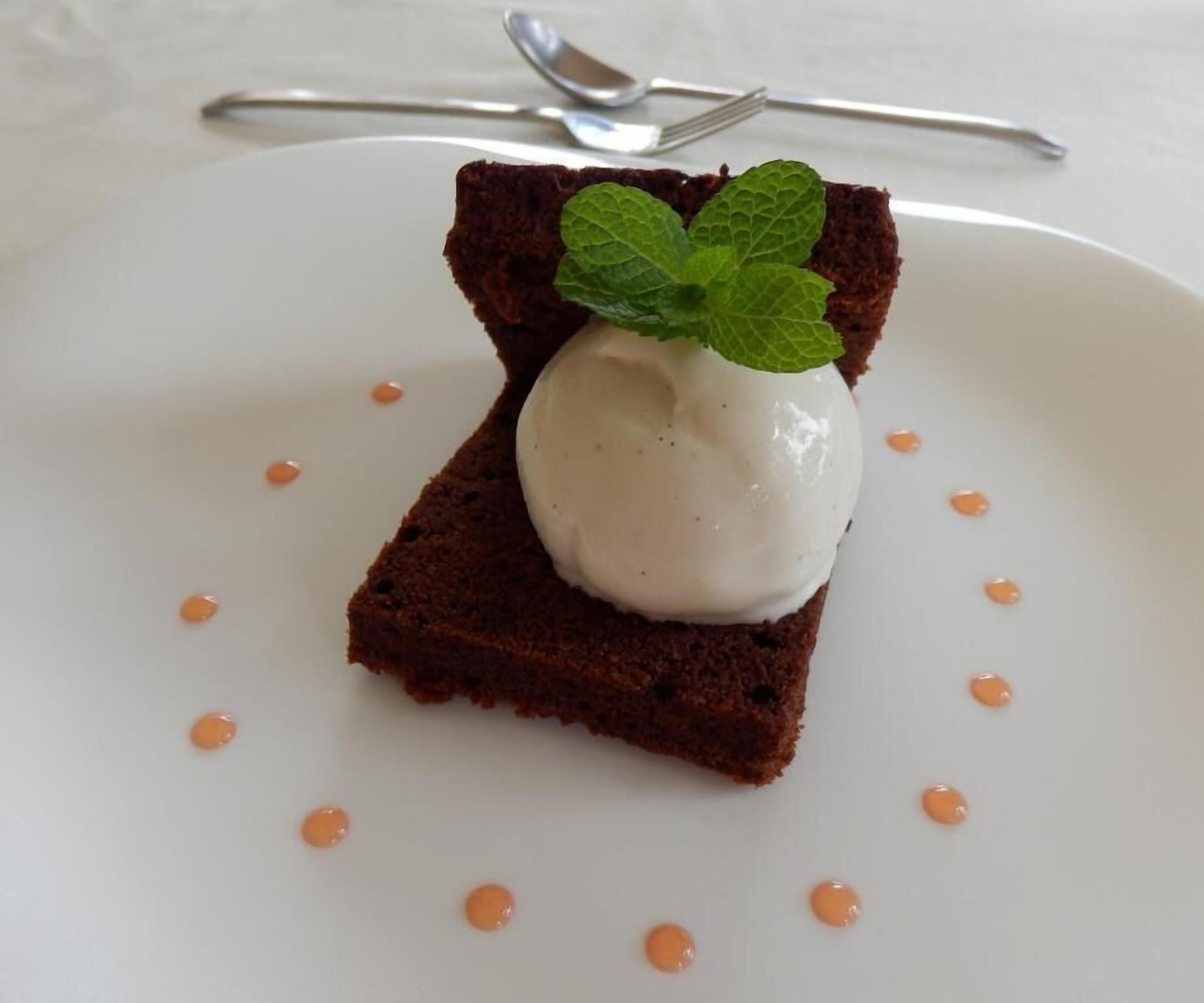 Un postre sobre un plato blanco con una ramita de menta.