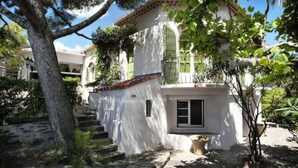 Un edifici blanc amb teulada vermella, un petit balcó i una porta amb finestral.