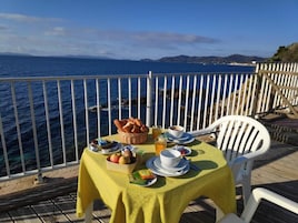 Una mesa con desayuno, con vista al mar.