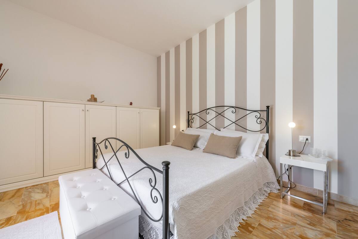 Un dormitorio con cama, mesita de noche y armario.