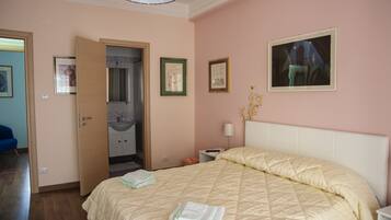 Une chambre à coucher avec un lit, une table de chevet, une lampe et un tableau au mur.