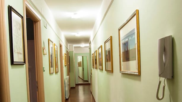 A long, narrow hallway with wooden flooring and light green walls. - Alma B&B (Crotone)