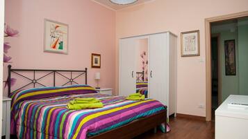 A bedroom with a bed, a wardrobe, and a desk.