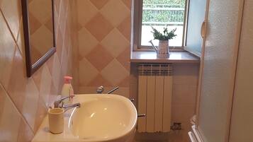 Ein Badezimmer mit Waschbecken, Toilette und Fenster.