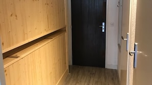 A narrow hallway with wooden paneling on one side and a dark door at the end. - Studio in Tignes with wifi near the slopes (Tignes)