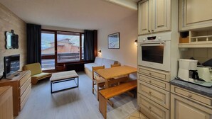 A compact kitchen with a dining area, a built-in oven, and a coffee machine. - Southwest studio in Tignes, near slopes, 27 m² (Tignes)