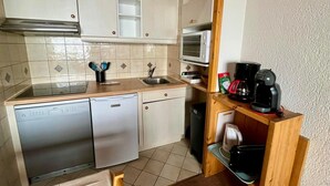 A compact kitchen with a dishwasher, microwave, and coffee maker. - 2-room south-facing, ski-in/ski-out, balcony, TV, linen included (Tignes)
