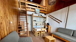 A compact living space with a loft bed, kitchenette, and seating area. - 2-room south-facing, ski-in/ski-out, balcony, TV, linen included (Tignes)