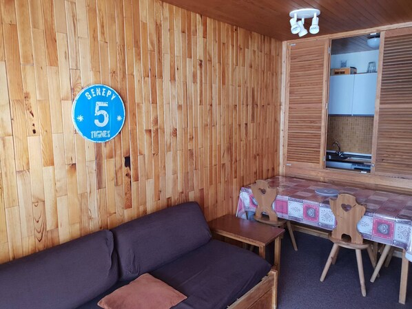 A wooden interior with a sofa, a small table, and a cabinet with a sink.