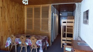 A wooden room with a table and chairs, a bunk bed, and a ceiling light fixture. - Studio at the foot of the slopes with south balcony in Tignes (Tignes)