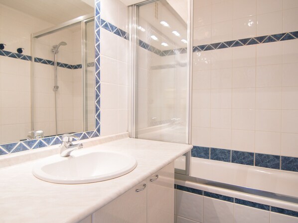 A bathroom with a white sink, mirror, and bathtub. - Southwest studio, ski-in/ski-out, wifi included (Tignes)