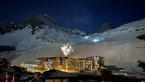 A snow-covered mountain landscape at night with a lit building in the foreground. - Renovated 3-room apartment, south/west facing, near shops (Tignes)