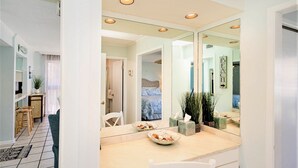 A modern kitchen with a large island, white cabinetry, and a mirrored backsplash. - 🏝️🏖️Sandpiper Cove, Private Beach Access Overlooks Heated Pool (Destin)