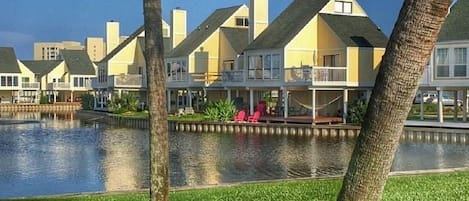 A waterfront property with multiple houses, a grassy area, and a body of water.
