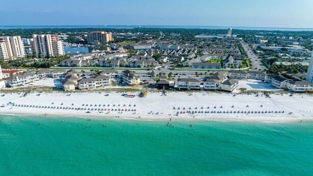 An aerial view of a coastal resort area with beachfront properties, a marina, and a clear view of the ocean. - 🏝️🏖️Sandpiper Cove, Private Beach Access Overlooks Heated Pool (Destin)