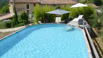 Een seizoensgebonden buitenzwembad en parasols bij het zwembad