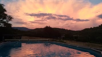 Una piscina al aire libre de temporada, sombrillas