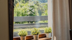 A window with a view of a hillside and potted plants on the sill. - Perła Beskidu (Ustron)
